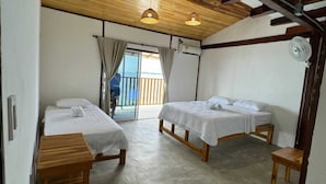 A room with two wooden beds, a ceiling fan, and a view through a glass door. - W cabañas beach, ocean view room 301, two steps from the sea. (Bolívar)