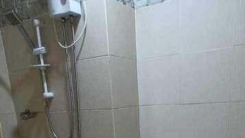A bathroom with a shower, toilet, and a water heater.