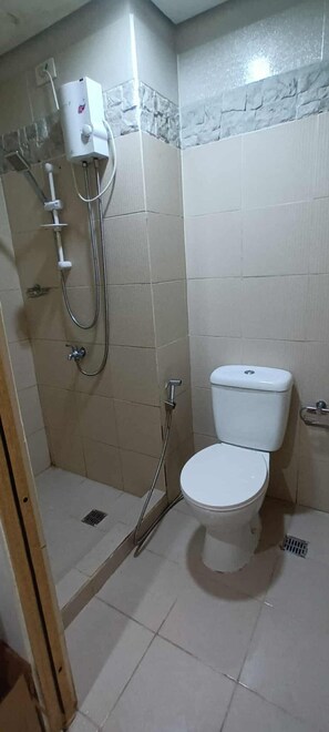 Shower, bidet, towels, toilet paper - Cozy High-Rise Haven (Quezon City)