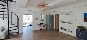 A spacious living area with a staircase, a piano, and a dining area with a view.