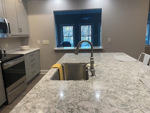A kitchen with a sink, stove, and cabinets. - Conestoga Manor  (Lancaster)