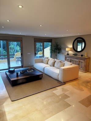 A modern living room with a sectional sofa, a dark coffee table, and a fireplace. - Semi-detached house (Marbella)