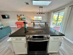 Une cuisine moderne équipée d’une cuisinière à gaz, d’un four et d’un coin repas avec une table et des chaises.