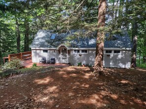 A cabin with a porch, a covered picnic table, and a small deck.