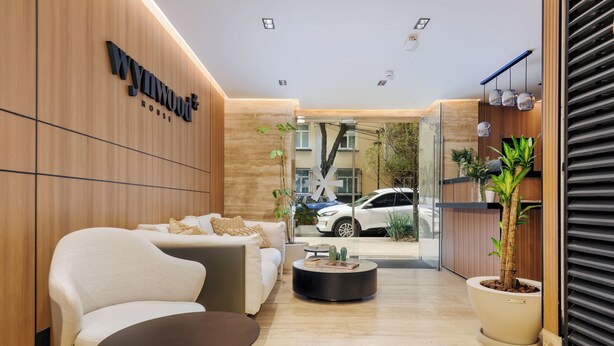 Un interior moderno con una recepción, zona de estar y vista a la calle.
