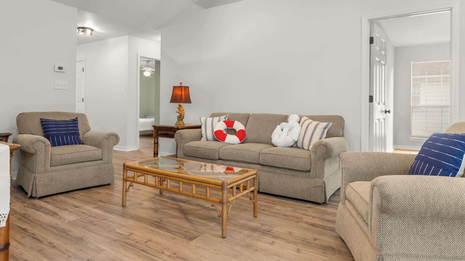 A living room with a sofa, two armchairs, a coffee table, and a lamp.