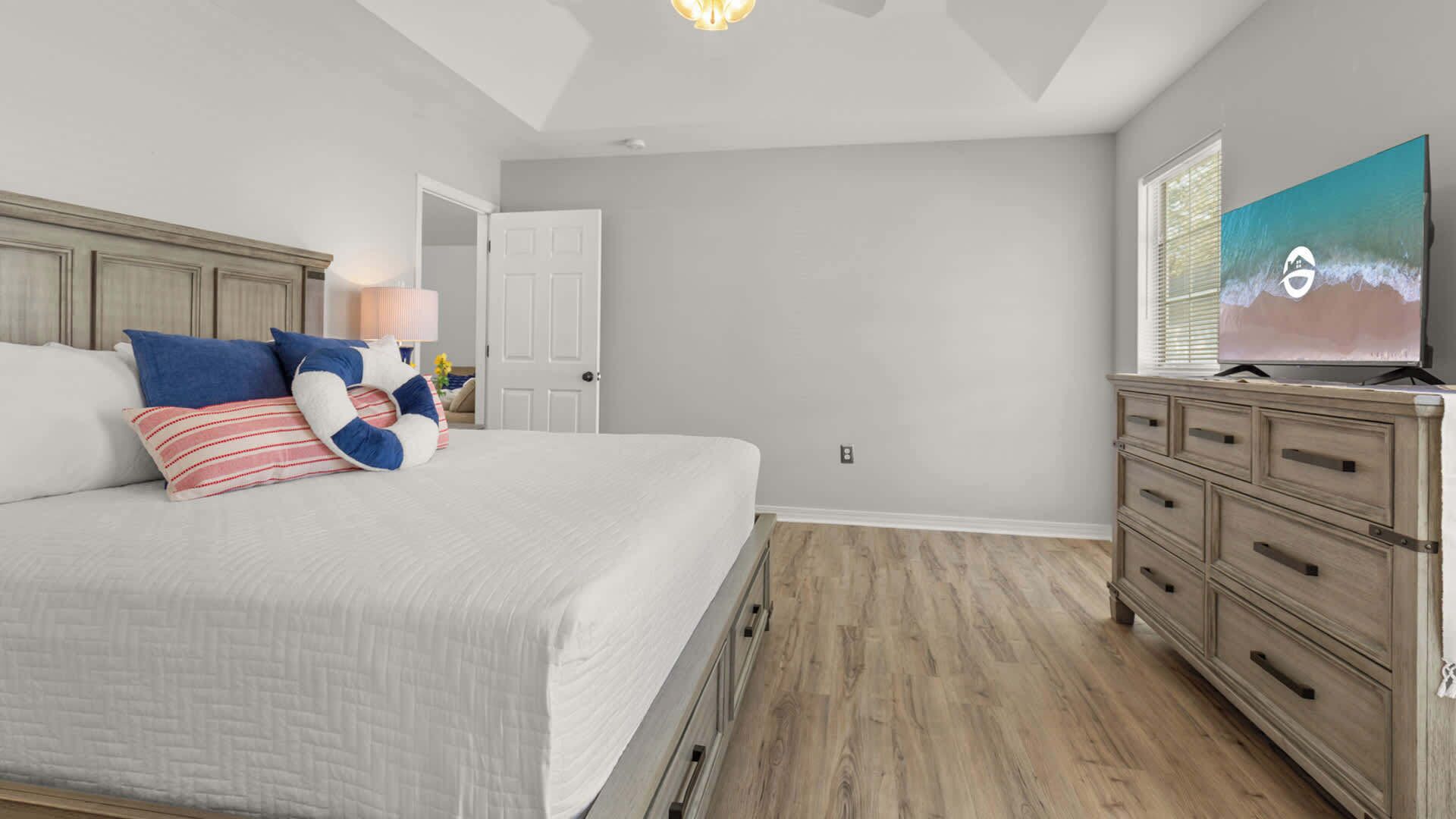 A bedroom with a bed, dresser, and a painting on the wall.