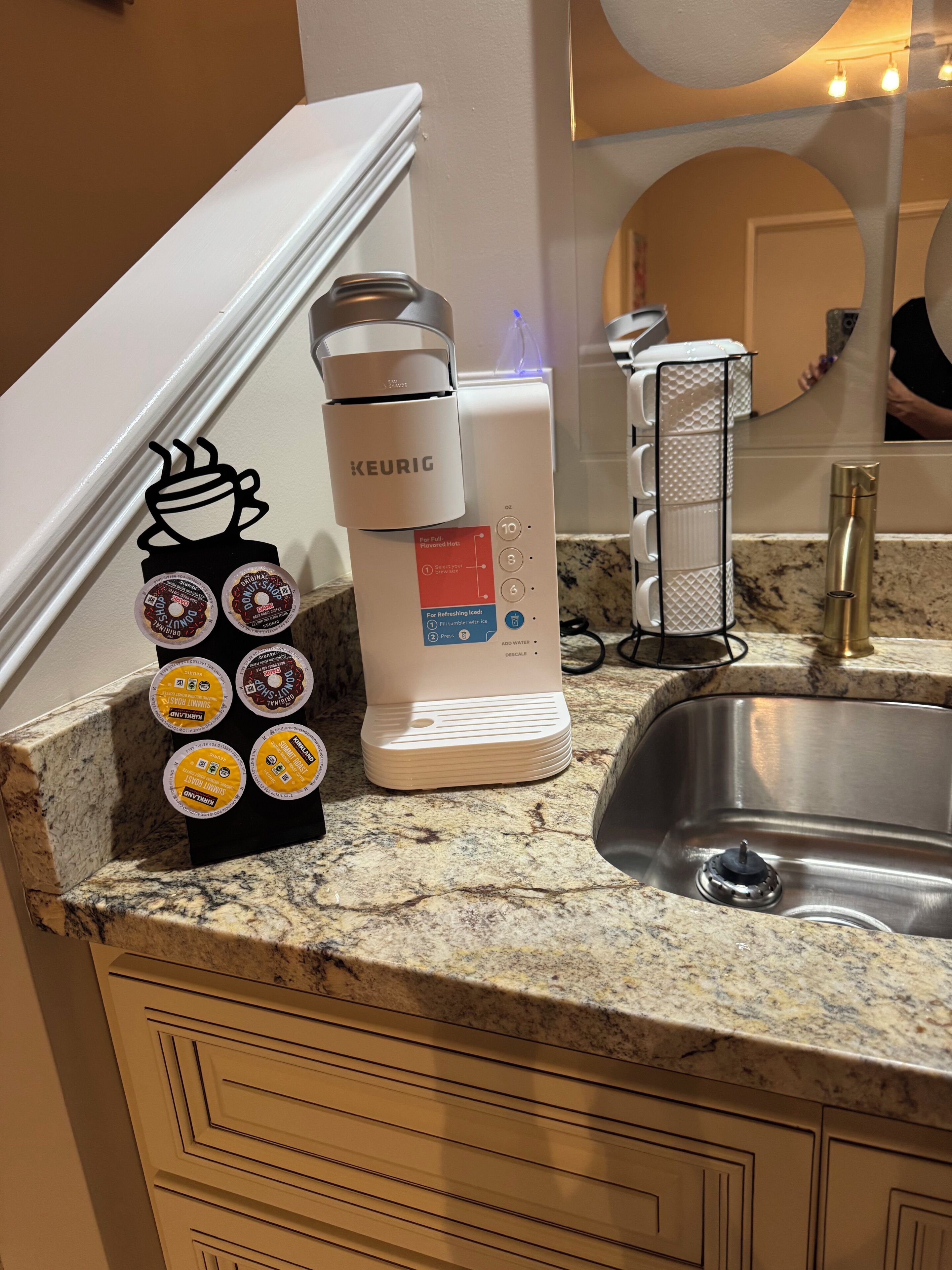 Eine Küchenarbeitsplatte mit Kaffeemaschine, Wasserkocher und Kaffee-Pod-Halterung.