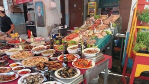 Diversos platos de mariscos presentados sobre una mesa con piso de baldosas.