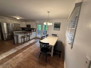 A kitchen with a central island, stainless steel appliances, and a dining area with a table and chairs. - New listing - Resort access! - Cute 2-bedroom house in beautiful Lake Lure (Lake Lure)