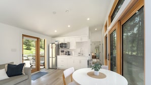 A modern kitchen with white cabinets, a microwave, and a sink. - North Star Ranch Modern Cabin by Beaver Lakes (Whitefish)