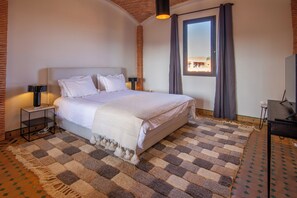 A hotel room with a bed, nightstands, a TV, and a window with curtains. - Golf villa amelkis 4 bedrooms (Marrakech)