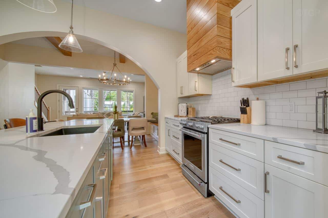 A modern kitchen with white cabinetry, a large island, and a central island with seating.