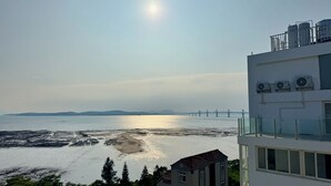 A coastal view with a bridge, buildings, and a clear sky. - CP Tide whisper (Jinning)