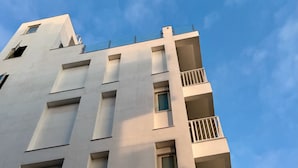 A modern building with a flat facade, multiple balconies, and rectangular windows. - CP Tide whisper (Jinning)