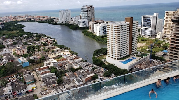 A high-rise building with a swimming pool, overlooking a river and cityscape. - Apartment With Great View Near Beach & Walled City (Cartagena)