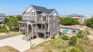 A two-story house with a balcony, a deck, and a swimming pool. - Saltwater Pool | Hot Tub | Rec Room | Dogs OK (Corolla)