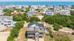 A coastal residential area with houses, a swimming pool, and a beach. - Saltwater Pool | Hot Tub | Rec Room | Dogs OK (Corolla)
