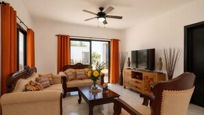 A living room with a sofa, armchairs, a coffee table, a TV, and a ceiling fan. - Sun-Filled Villa • Sunlit Pool • Just Finished (Sosúa)