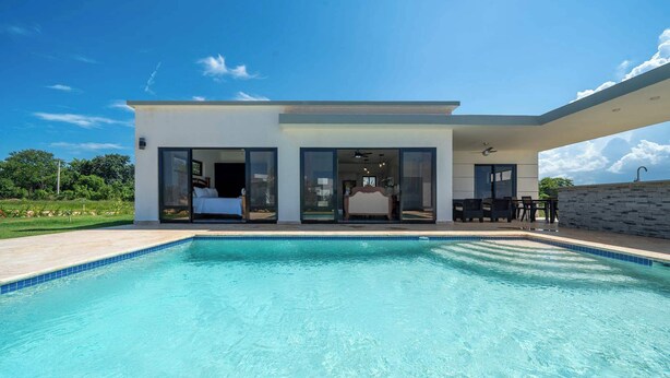 A modern house with a swimming pool, large glass doors, and a patio area. - Sun-Filled Villa • Sunlit Pool • Just Finished (Sosúa)