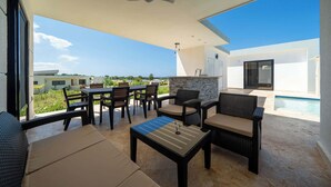 A modern outdoor patio with a dining area, seating, and a pool. - Sun-Filled Villa • Sunlit Pool • Just Finished (Sosúa)