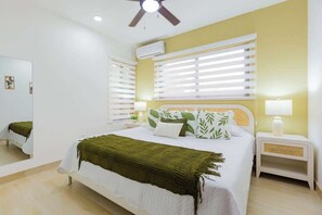 A bedroom with a bed, bedside tables, a ceiling fan, and a window with blinds. - Modern • Private • Relax (Sosúa)