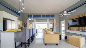 Una cocina moderna con barra, sofá y televisor.