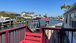 A marina with docked boats, a red chair, and houses along the water. - Perfect Home in St. James City (Saint James City)