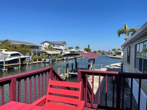 A marina with docked boats, a red chair, and houses along the water. - Perfect Home in St. James City (Saint James City)