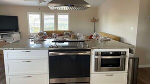 A modern kitchen with a central island, built-in oven, and a ceiling fan. - Perfect Home in St. James City (Saint James City)