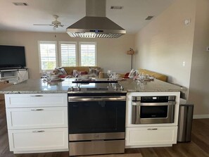 A modern kitchen with a central island, built-in oven, and a ceiling fan. - Perfect Home in St. James City (Saint James City)