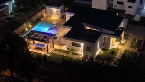 A modern house with a swimming pool, outdoor seating, and a well-lit garden. - Modern Villa · Pool, Jacuzzi & Pool Table · Sosúa (Sosúa)