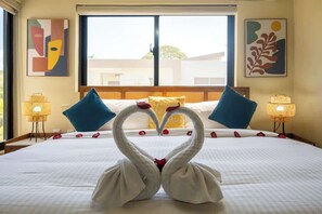 A hotel room with a bed, two wall-mounted lamps, and abstract art on the walls. - Modern 2BR Villa · Private Pool · Casa Linda (Sosúa)