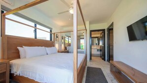 Ein modernes Hotelzimmer mit einem großen Bett, einem Fernseher und Blick ins Freie.