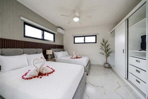 A hotel room with two beds, a ceiling fan, a TV, and a potted plant. - Soaring Pool Villa  •  Detached Pool Casita (Sosúa)