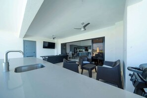 Una cocina moderna con una isla grande, un fregadero integrado y una zona de comedor con asientos.