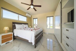 A bedroom with a bed, a nightstand, a ceiling fan, and a TV. - Private Tropical Retreat • Pool Villa (Sosúa)