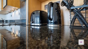 A kitchen with a granite countertop, stainless steel appliances, and a wooden cabinet. - BRIGHTON CENTRAL TRENDY LONGSTAY, WALK TO BEACH (Brighton and Hove)