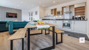 A modern kitchen with a dining area, a flat-screen TV, and a sofa. - BRIGHTON CENTRAL TRENDY LONGSTAY, WALK TO BEACH (Brighton and Hove)