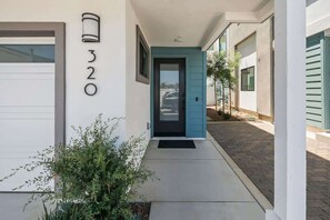 A modern building with a blue door, a garage, and a number '320' on the wall. - 3 Minute Walk to Beach 4 Bedroom Home (Carlsbad)