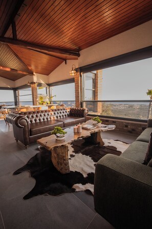 Un intérieur moderne avec un canapé en cuir, une table basse en bois et un tapis en peau de vache.