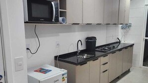 Eine Küche mit Mikrowelle, Herd und Kühlschrank.