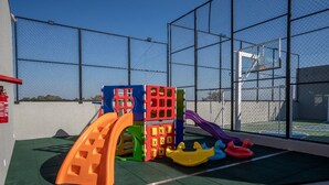 Ein Spielplatz mit Rutsche, Klettergerüsten und Schaukeln.
