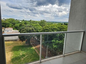 Varanda com vista para uma paisagem verde e uma estrada.
