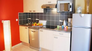 Una cocina compacta equipada con lavavajillas, microondas y refrigerador.