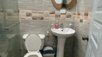 Een badkamer met toilet, wastafel en spiegel.