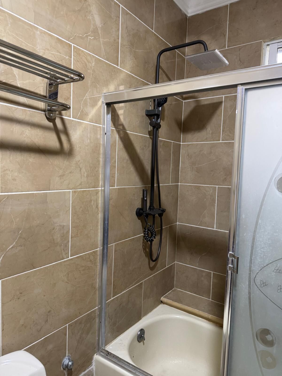 Een badkamer met een douchecabine, een bad en een toilet.
