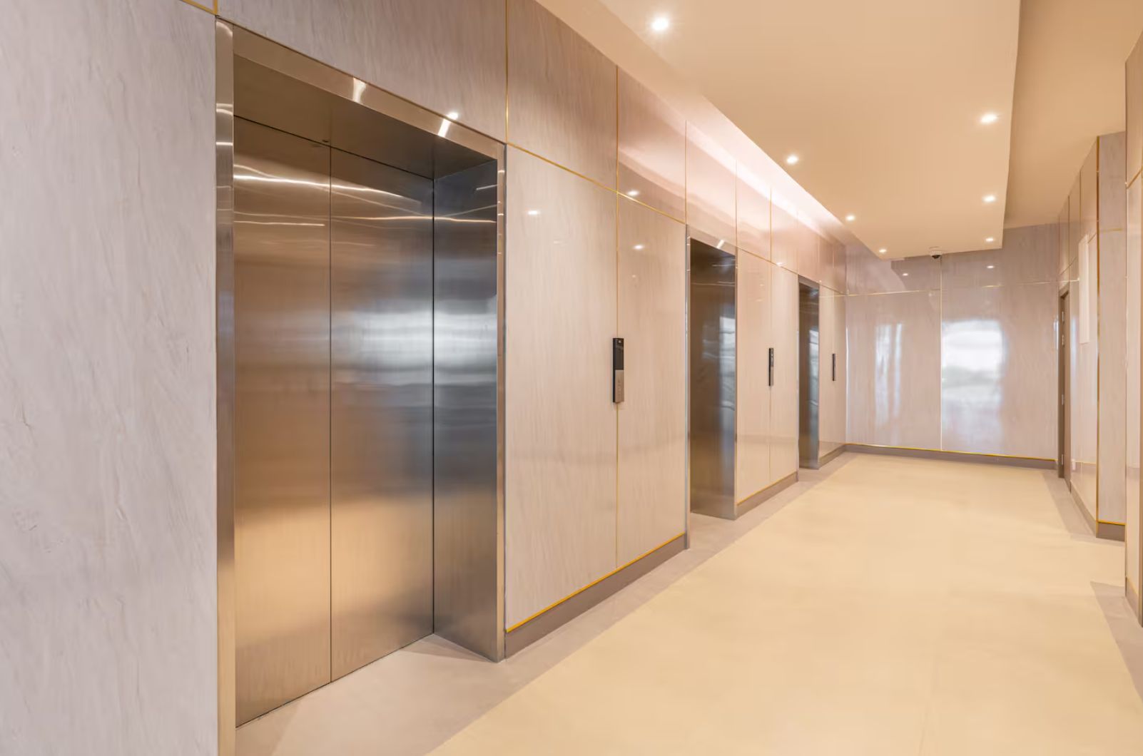 Un ascenseur moderne doté de portes métalliques et d’un panneau de commande, qui fait partie de l’aménagement intérieur d’un immeuble.