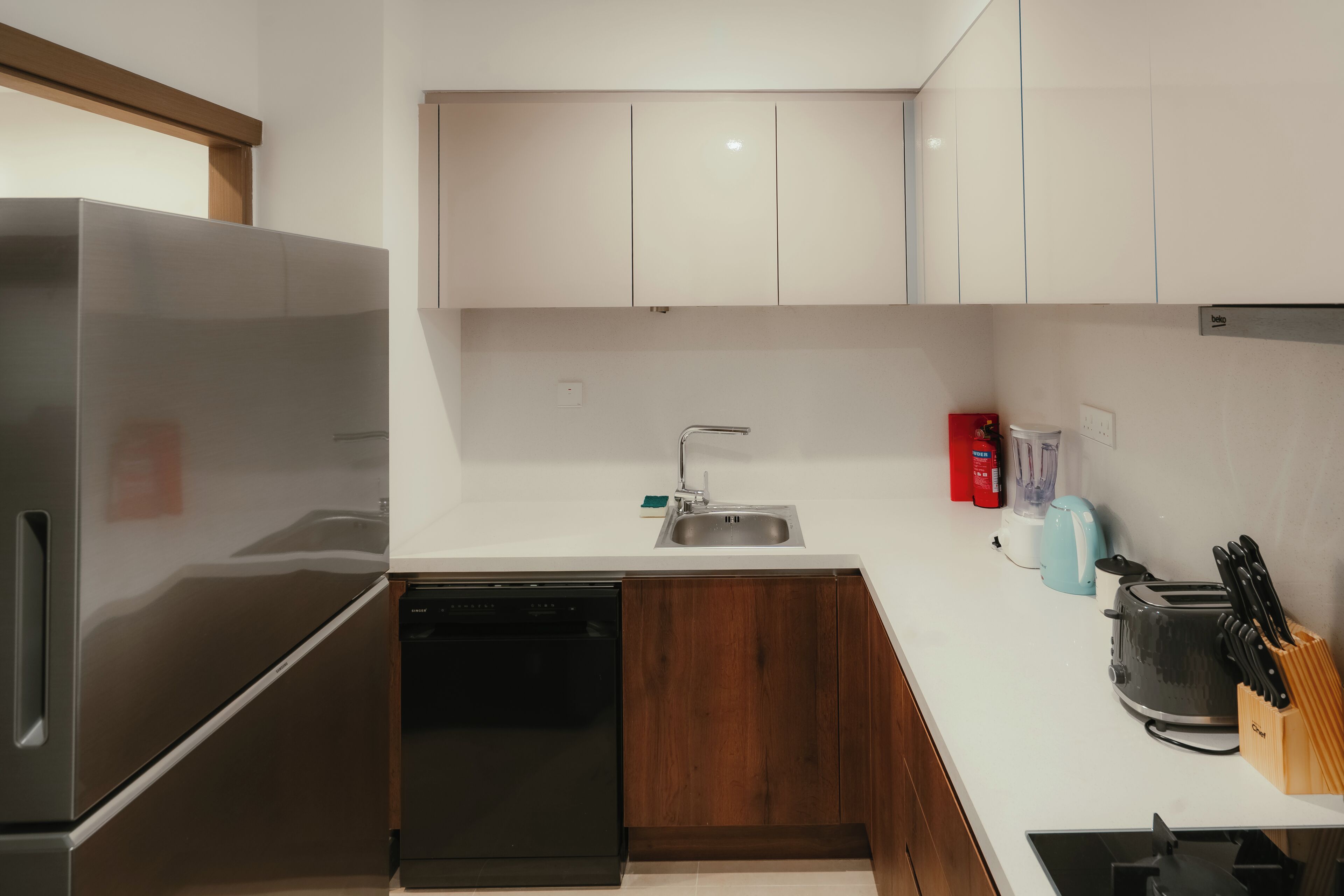 A modern kitchen with stainless steel appliances, a dishwasher, and a sink.