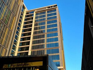 A tall building with a modern architectural design, featuring a prominent glass facade and a series of horizontal lines. - Hotel Costanera Concepcion (Concepción)